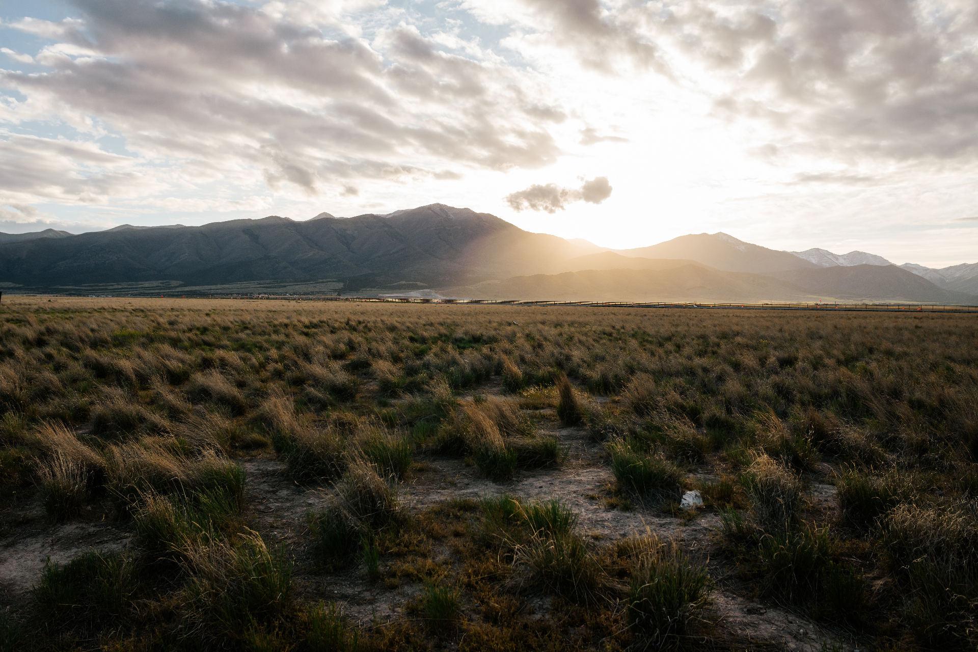 Sun setting behind the mountains over an Eagle Mountain field